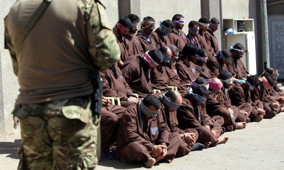 16일(현지시간) 이라크 수도 바그다드에 위치한 이라크 국가정보원 청사 앞에 이라크 정부군이 이슬람 수니파 무장단체 ‘이슬람국가’(IS) 대원으로 추정되는 31명의 인질을 포위하고 있다. 이라크 국가정보원은 최근 바그다드에서 발생한 52건의 공격을 계획·실행한 데에 책임이 있는 31명의 IS 대원들을 체포했다고 밝혔다. ⓒAFPBBNews=News1