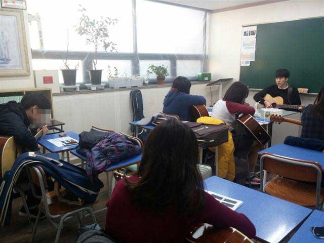 17일 서울 관악구에 있는 우리들학교 학생들이 자원봉사자 최진수(오른쪽)씨의 지도로 기타 연주를 배우고 있다.