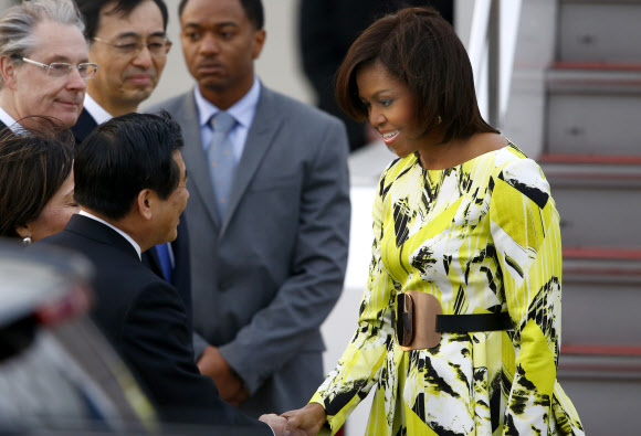 일본을 처음 방문한 미국 퍼스트레이디 미셸 오바마(오른쪽)가 도쿄 하네다 국제공항에서 영접 나온 일본 관료와 악수하고 있다.  도쿄 AP 연합뉴스
