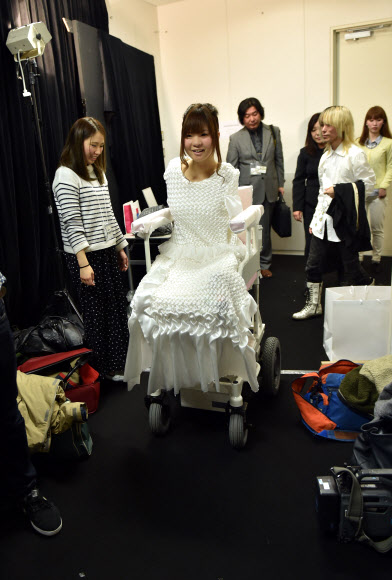 도쿄패션위크가 열린 18일(현지시간) 일본 디자이너 다카후미 츠루타가 디지안한 브랜드 ‘텐보’의 2015/16 가을/겨울 컬렉션 패션쇼 시작 전 장애우 모델 사노 아미가 전동 휠체어에 앉아 무대 오르기 전 점검을 받고 있다.  ⓒAFPBBNews=News1