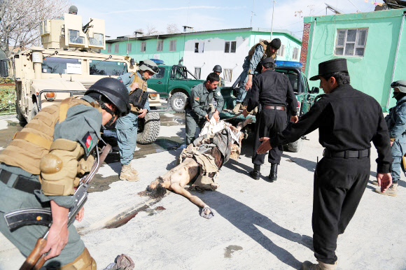 19일(현지시간)  아프가니스탄 간지 주 안다르 지역의 한 마을에서 이슬람 원리주의 무장세력 탈레반과 아프간 치안군 간의 한바탕 전투가 끝난 후 아프간 국가경찰(ANP)들이 마프간 대원으로 추정되는 시신을 수습하고 있다. ⓒAFPBBNews=News1