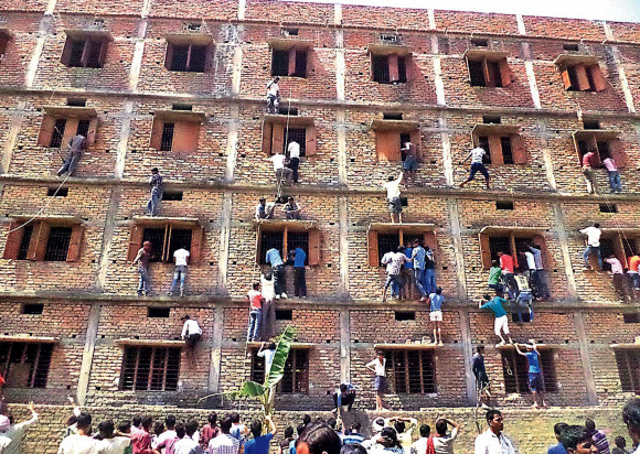 18일(현지시간) 고교 입학 자격시험(10학년 시험)이 치러진 인도 동부 비하르 주 하지푸르의 한 고사장 밖에서는 시험 시작 종이 울리자 수십 명의 학부모가 5층 고사장 건물의 벽을 타고 오르기 시작했다. AP/뉴시스