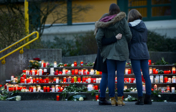 24일(현지시간) 독일 한테른 암 제의 한 중고등학교 앞에 독일 저먼윙스 여객기 추락사고의 희생자들을 위한 꽃과 양초로 만들어진 추모 공간이 마련된 가운데 학생들이 모여 슬퍼하고 있다. 스페인 바르셀로나에서 출발해 독일 뒤셀도르프로 향하던 저먼윙스 여객기 추락으로 이 학교의 같은 반 학생 16명이 사망했다. ⓒAFPBBNews=News1