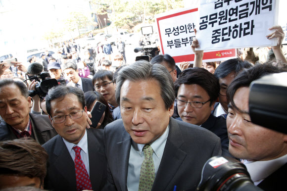 새누리당 김무성 대표가 25일 오후 성동구 한양대 백남음악관에서 강연을 위해 들어서고 있다. 뒷쪽은 김대표를 비난하는 한국청년연대, 알바노조  등이 피켓 시위를 하고 있다.  연합뉴스