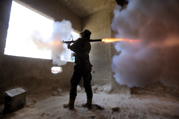 25일(현지시간) 시리아 수도 다마스쿠스에서 ‘공화국 수비대대’ 소속 시리아 여성 군인이 로켓추진식 수류탄을 발사하고 있다. ⓒAFPBBNews=News1