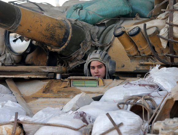 25일(현지시간) 시리아 수도 다마스쿠스에서 ‘공화국 수비대대’ 소속 시리아 여성 군인이 탱크를 조종하고 있다.  ⓒAFPBBNews=News1
