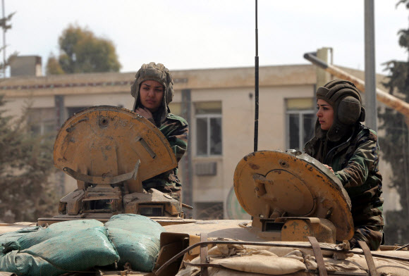 25일(현지시간) 시리아 수도 다마스쿠스에서 ‘공화국 수비대대’ 소속 시리아 여성 군인이 탱크를 조종하고 있다.  ⓒAFPBBNews=News1