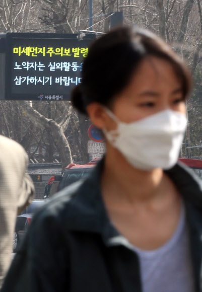 서울 지역에 미세먼지 주의보가 발령된 30일 오후 서울 태평로 거리에서 한 시민이 마스크를 쓴 채 이동하고 있다.  연합뉴스