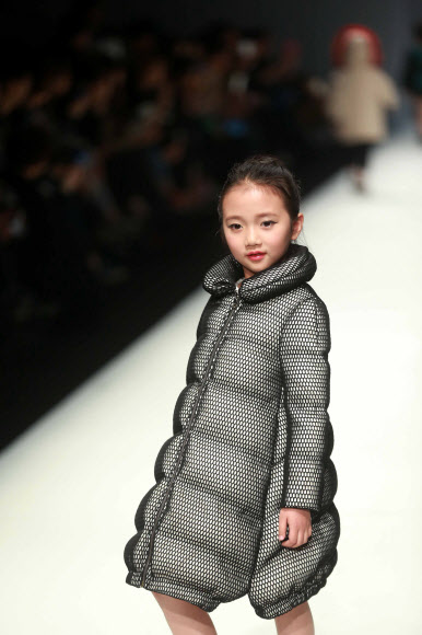 31일(현지시간) 중국 베이징의 중국패션위크가 열린 가운데 ‘선 투모로우 어린이 컬렉션’ 의상을 입은 귀여운 어린이가 무대 위에서 포즈를 취하고 있다. ⓒAFPBBNews=News1