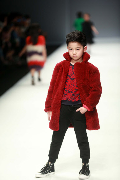 31일(현지시간) 중국 베이징의 중국패션위크가 열린 가운데 ‘선 투모로우 어린이 컬렉션’ 의상을 입은 귀여운 어린이가 무대 위에서 포즈를 취하고 있다. ⓒAFPBBNews=News1