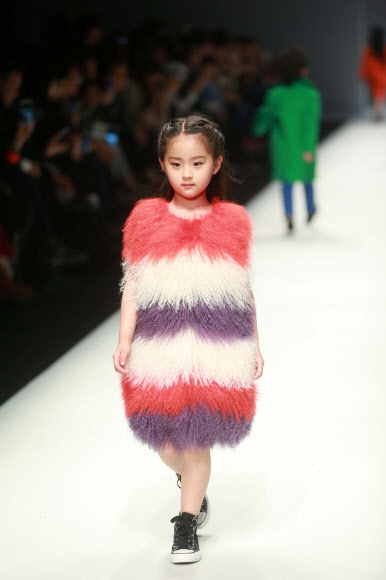 31일(현지시간) 중국 베이징의 중국패션위크가 열린 가운데 ‘선 투모로우 어린이 컬렉션’ 의상을 입은 귀여운 어린이가 무대 위에서 포즈를 취하고 있다. ⓒAFPBBNews=News1