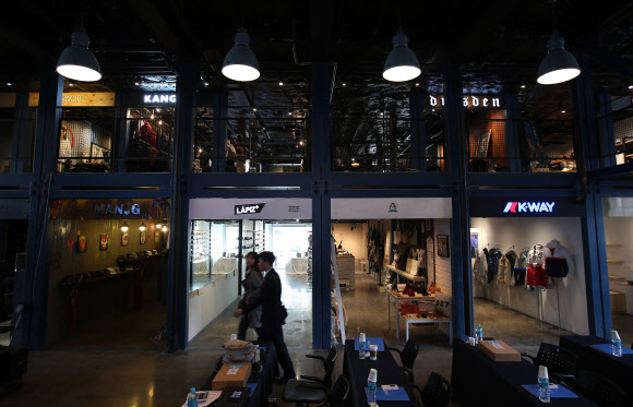 한국판 ’컨테이터 파크’가 건대입구 인근에 들어선다. 코오롱인더스트리FnC부문은 이달 10일 건대 상권에 국내 최초의 컨테이너 복합 쇼핑몰인 ’커먼 그라운드’를 열고 유통사업을 본격화한다고 8일 밝혔다. 커먼그라운드는 에바주니·웨이즈스펠·문샷·뉴에라·반스 등 56개의 패션브랜드, 도레도레·더 부스·아날로그 키친·김치버스 16개의 식음료 브랜드 등이 들어선 쇼핑 공간과 공연·전시가 가능한 문화 공간으로 구성된 쇼핑몰이다. 사진은 이날 오후 서울 광진구 자양동에 위치한 ’커먼 그라운드’ 내부.  연합뉴스