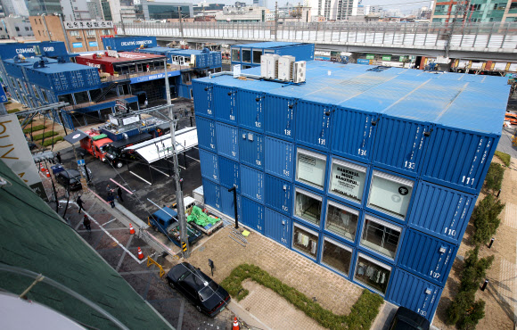 한국판 ’컨테이터 파크’가 건대입구 인근에 들어선다. 코오롱인더스트리FnC부문은 이달 10일 건대 상권에 국내 최초의 컨테이너 복합 쇼핑몰인 ’커먼 그라운드’를 열고 유통사업을 본격화한다고 8일 밝혔다. 커먼그라운드는 에바주니·웨이즈스펠·문샷·뉴에라·반스 등 56개의 패션브랜드, 도레도레·더 부스·아날로그 키친·김치버스 16개의 식음료 브랜드 등이 들어선 쇼핑 공간과 공연·전시가 가능한 문화 공간으로 구성된 쇼핑몰이다. 사진은 이날 오후 서울 광진구 자양동에 위치한 ’커먼 그라운드’.  연합뉴스