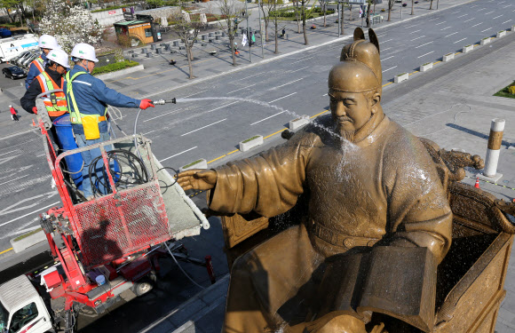 13일 오전 서울 광화문광장에서 서울시 관계자들이 세종대왕 동상을 세척하고 있다.  연합뉴스