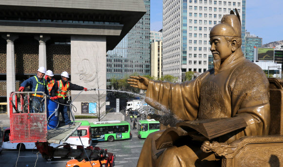 13일 오전 서울 광화문광장에서 서울시 관계자들이 세종대왕 동상을 세척하고 있다.  연합뉴스