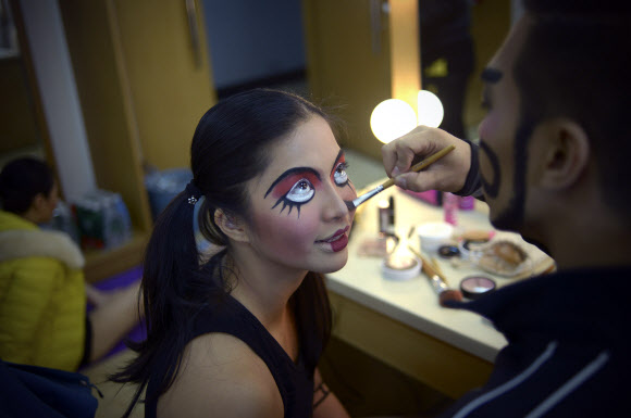 12일(현지시간) 중국 베이징의 2015 세계 폴댄스 선수권 대회가 시작되기 전 폴댄서가 대기실에서 메이크업을 받고 있다. 4개 대륙 10개국 이상의 나라에서 참가한 폴댄서들은 폴 댄스가 올림픽 정식 종목으로 채택되어야 한다고 주장하고 있다.  ⓒAFPBBNews=News1