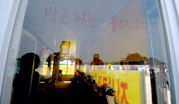 세월호 사고 1주기인 16일 전남 진도 팽목항에 설치된 합동분향소가 박근혜대통령의 방문예정을 기점으로 폐쇄된 가운데 폐쇄된 합동분향소에 박근혜 대통령을 비난하는 글귀가 써 있다.  박지환기자 popocar@seoul.co.kr