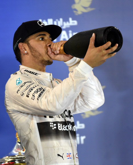 영국의 루이스 해밀턴(30·메르세데스)이 19일(현지시간) 바레인 사키르에서 열린 국제 자동차 경주대회 포뮬러원(F1) 바레인 그랑프리 대회에서 우승한 후 “Warrd”라고 불리는 스파클링 음료를 마시고 있다. ⓒAFPBBNews=News1
