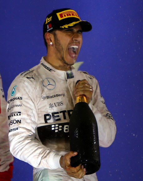 영국의 루이스 해밀턴(30·메르세데스)이 19일(현지시간) 바레인 사키르에서 열린 국제 자동차 경주대회 포뮬러원(F1) 바레인 그랑프리 대회에서 우승한 후 “Warrd”라고 불리는 스파클링 음료를 마시고 있다. ⓒAFPBBNews=News1