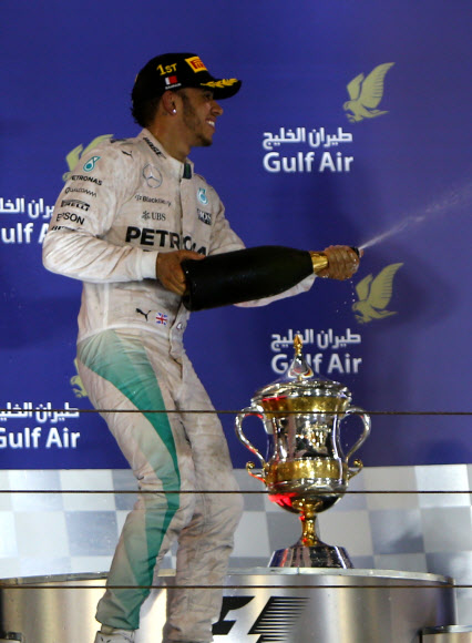 영국의 루이스 해밀턴(30·메르세데스)이 19일(현지시간) 바레인 사키르에서 열린 국제 자동차 경주대회 포뮬러원(F1) 바레인 그랑프리 대회에서 우승한 후 “Warrd”라고 불리는 스파클링 음료를 주위 사람들에게 뿌리고 있다. ⓒAFPBBNews=News1