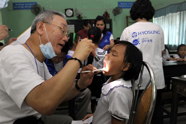 효성 미소원정대 봉사에 참여한 의사가 지난해 8월 베트남 호찌민 어린이의 치아 상태를 검사하고 있다.  효성그룹 제공