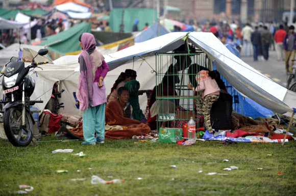 대지진이 발생한 네팔에서 26일(현지시간) 수십차례의 여진이 이어지자 공포를 느낀 카트만두의 주민들이 집을 빠져나와 군부대 앞 잔디광장에서 노천 생활을 하고 있다. ⓒAFPBBNews=News1