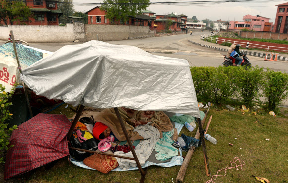 대지진이 발생한 네팔에서 26일(현지시간) 수십차례의 여진이 이어지자 공포를 느낀 카트만두의 주민들이 집을 빠져나와 길가에 임시 텐트를 치고 노천 생활을 하고 있다. ⓒAFPBBNews=News1