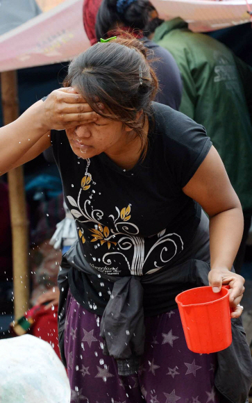 네팔 대지진 공식 사망자가 6100명을 넘어선 가운데 1일 임시 텐트에서 생활하고 있는 카트만두 주민이 컵에 담긴 물로 얼굴을 씻고 있다.  카트만두(네팔) 손형준 기자 boltagoo@seoul.co.kr