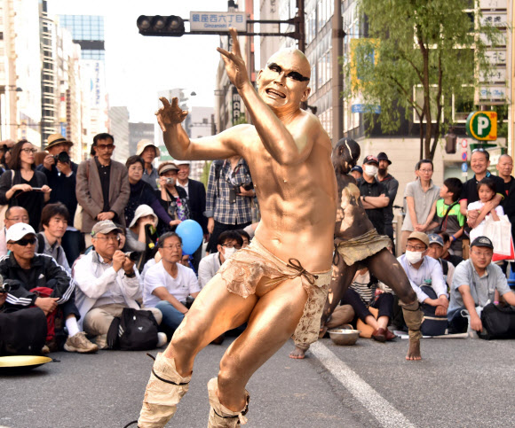 5일(현지시간) 일본 도쿄에서 부토 페스티벌이 열리고 있는 가운데 아방가르드 무용단 ‘다이라쿠다칸’ 단원들이 온몸을 황금색으로 분장하고 퍼포먼스를 선보이고 있다. 일본의 골든 위크 기간인 지난달 29일부터 5월 5일까지 진행되는 긴자 야나기 거리 페스티벌은 게이샤의 춤과 스트릿 퍼포먼스를 볼 수 있는 행사다.  ⓒAFPBBNews=News1