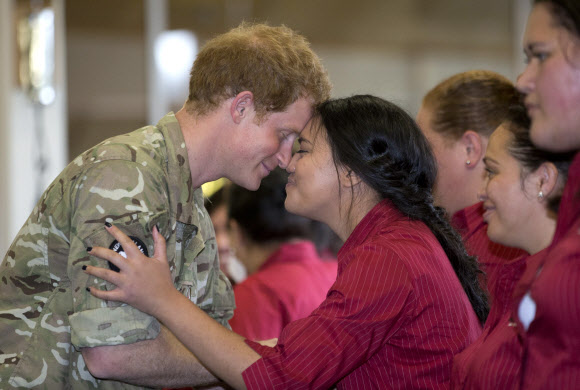 Britain’s Prince Harry (L) receives a “hongi”, a traditional Maori greeting, from Kairanga Kapa Hake group performer Anicacane Papanui (C) during a visit to Linton Military Camp in Linton, near Palmerston North, on May 13, 2015. Prince Harry arrived in New Zealand on May 9 for a week-long visit.