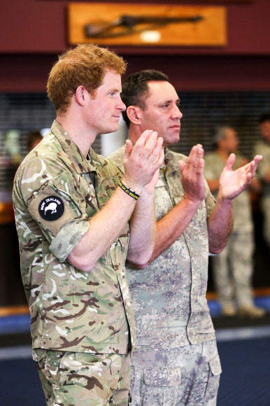 Britain’s Prince Harry (L) applauds after watching a “kapa haka” group perform during a visit to Linton Military Camp in Linton, near Palmerston North, on May 13, 2015.