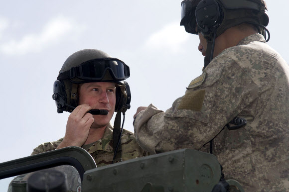 Britain’s Prince Harry (L) sits in a New Zealand Army light armoured vehicle (LAV) with NZA personnel during a visit to Linton Military Camp in Linton, near Palmerston North, on May 13, 2015.