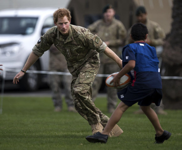 Britain’s Prince Harry plays a game of touch rugby with children during a visit to Linton Military Camp in Linton, near Palmerston North, on May 13, 2015.