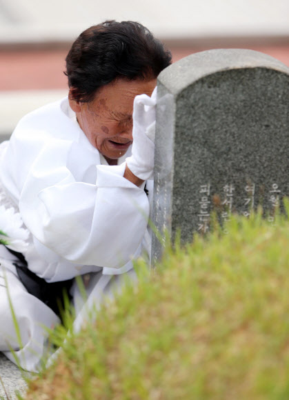 제 35주년 광주민주화운동 기념식을 하루 앞둔 17일 오전 광주 북구 운정동 국립 5·18민주묘지를 찾은 한 오월 어머니가 비석을 쓰다듬으며 오열하고 있다.  연합뉴스