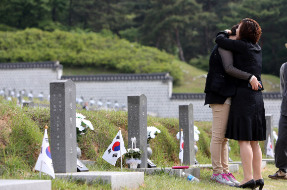 제 35주년 광주민주화운동 기념식을 하루 앞둔 17일 오전 광주 북구 운정동 국립 5·18민주묘지를 찾은 유가족들이 묘지 앞에서 슬픔에 젖어 있다.  연합뉴스