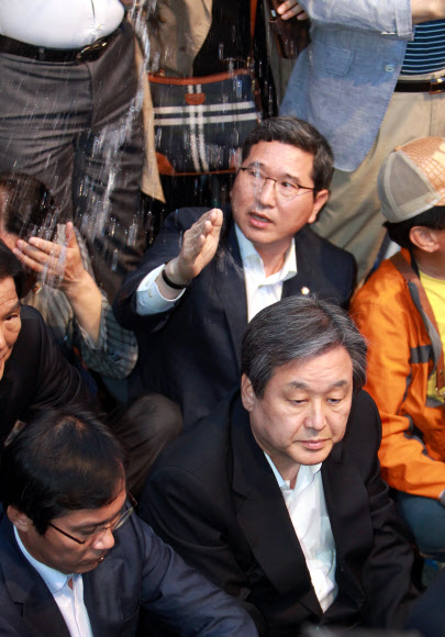김무성(오른쪽) 새누리당 대표가 17일 광주 동구 금남로에서 열린 5·18 광주민주화운동 전야제에 참석했다가 광주 방문을 반대하는 시민들에게 물세례를 받고 있다. 광주 연합뉴스
