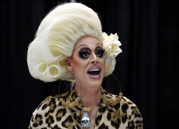 17일(현지시간) 미국 캘리포니아 로스앤젤레스(LA) 컨벤션 센터에서 열린 여장남자 행사 참석자가 팬을 보며 웃고 있다. ⓒAFPBBNews=News1