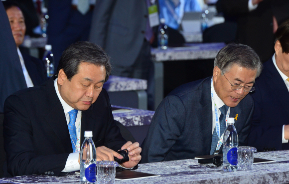 새누리당 김무성 대표가 20일 오전 서울 동대문디자인플라자에서 열린 서울디지털포럼2015 개막식 행사에 참석해 새정치민주연합 문재인 대표가 자리에 앉는 동안 통역기 작동을 확인하고 있다. 2015. 05. 20 안주영 jya@seoul.co.kr