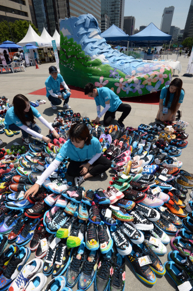 서울시립청소년문화교류센터가 21일 서울 광화문 광장에서 몽골 빈곤 청소년에게 전달될 운동화를 전시하고 있다. 관세청과 공동 주최한 이번 행사는 짝퉁제품으로 몰수 된 운동화 10.290점을 시민들이 그림을 그려 보내질 예정이다. 2015.5.21 도준석 pado@seoul.co.kr