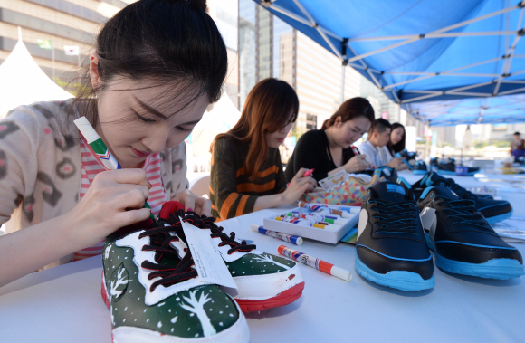 21일 서울 광화문 광장에서 열린 ‘2015 희망의 운동화 나눔축제’에 참가한 시민들이 몽골 빈곤 청소년에게 전달될 운동화에 그림을 그리고 있다. 관세청과 공동 주최한 이번 행사는 짝퉁제품으로 몰수 된 운동화 10.290점이 사용됐다. 2015.5.21 도준석 pado@seoul.co.kr