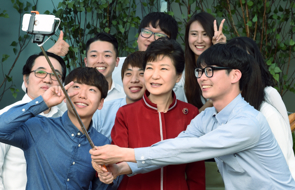 박근혜 대통령이 22일 충남 천안시 테크노파크에서 열린 충남창조경제 혁신센터 출범식에서 태양광을 응용해 만든 야외 클린 캠핑장에 관한 대화에 참여한 교수 학생들과 셀카봉으로 기념 촬영을 하고 있다. 2015. 05. 22 안주영 jya@seoul.co.kr