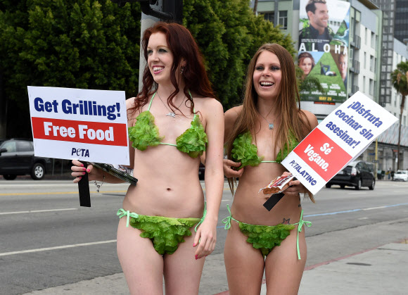 미국 워싱턴DC에서 21일(현지시간) 동물보호단체 PETA(People for the Ethical Treatment of Animals) 활동가들이 ‘상추 비키니’를 입고 사람들에게 채식 버거를 나눠주고 있다. ⓒ AFPBBNews=News1