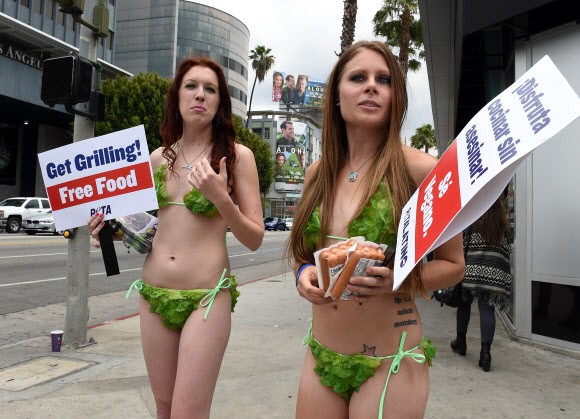 미국 워싱턴DC에서 21일(현지시간) 동물보호단체 PETA(People for the Ethical Treatment of Animals) 활동가들이 ‘상추 비키니’를 입고 사람들에게 채식 버거를 나눠주고 있다. ⓒ AFPBBNews=News1