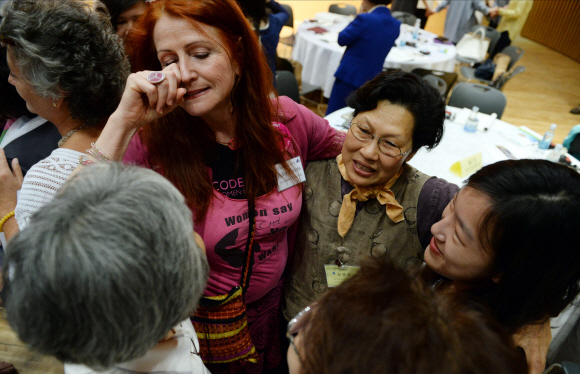 노벨평화상 수상자인 북아일랜드의 메어리드 매과이어와 라이베리아 출신 노벨평화상 수상자인 리마 보위회의 등 위민크로스DMZ 대표단과 참석자들이 25일 서울시청 다목적홀에서 열린 ‘2015 국제여성평화회의’ 개회 퍼포먼스로 서로 손을 잡고 상대방의 마음을 이해하는 시간을 갖고 있다. 2015. 5. 25. 박윤슬 seul@seoul.co.kr