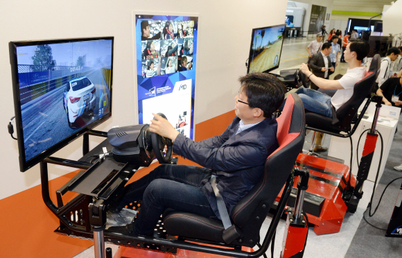 27일 서울 삼성동 코엑스에서 열린 국내 최대 IT 전시회 ‘월드 IT 쇼(World IT Show: WIS) 2015’를 찾은 시민이 체감형 가상현실레이싱시뮬레이터 ’탑드리프트’를 체험하고 있다. 2015. 5. 27. 박윤슬 seul@seoul.co.kr