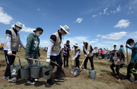 26일(현지시각) 대한항공 신입사원 및 임직원, 몽골 주민들이 몽골 올란바토르 바가노르 사막지역에서 버드나무, 포플러 나무 등 나무심기 봉사활동을 펼치고 있다. 지구를 푸르게 가꾸는 사회공헌 활동 ‘글로벌 플랜팅 프로젝트’의 일환으로 몽골사막에서 12년째 계속되고 있는 대한항공 숲 조성사업은 올해 1만여 그루를 심어, 총 44ha 면적에 9만여 그루의 나무들이 자라는 숲으로 조성된다. 이번 봉사활동은 대한항공 신입직원 등 임직원 170여명과 현지주민 등 총 600여명이 참여했다. 2015. 05. 27 바가노르 박지환 popocar@seoul.co.kr