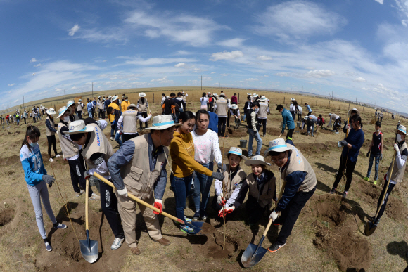26일(현지시각) 대한항공 신입사원 및 임직원, 몽골 주민들이 몽골 올란바토르 바가노르 사막지역에서 버드나무, 포플러 나무 등 나무심기 봉사활동을 펼치고 있다. 지구를 푸르게 가꾸는 사회공헌 활동 ‘글로벌 플랜팅 프로젝트’의 일환으로 몽골사막에서 12년째 계속되고 있는 대한항공 숲 조성사업은 올해 1만여 그루를 심어, 총 44ha 면적에 9만여 그루의 나무들이 자라는 숲으로 조성된다. 이번 봉사활동은 대한항공 신입직원 등 임직원 170여명과 현지주민 등 총 600여명이 참여했다. 2015. 05. 27 바가노르 박지환 popocar@seoul.co.kr