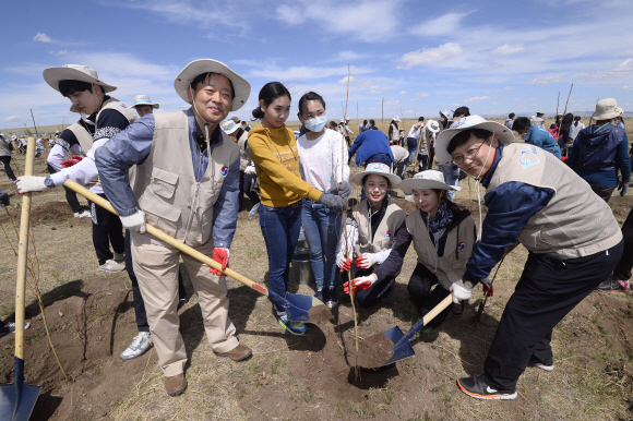 26일(현지시각) 이병호 대한항공 인력관리본부장(왼쪽에서 두번째), 채종훈 중국지역본부장(오른쪽) 등 임직원과 신입사원, 몽골 주민들이 몽골 올란바토르 바가노르 사막지역에서 버드나무, 포플러 나무 등 나무심기 봉사활동을 하고 있다. 지구를 푸르게 가꾸는 사회공헌 활동 ‘글로벌 플랜팅 프로젝트’의 일환으로 몽골사막에서 12년째 계속되고 있는 대한항공 숲 조성사업은 올해 1만여 그루를 심어, 총 44ha 면적에 9만여 그루의 나무들이 자라는 숲으로 조성된다. 이번 봉사활동은 대한항공 신입직원 등 임직원 170여명과 현지주민 등 총 600여명이 참여했다 2015. 05. 27 바가노르 박지환 popocar@seoul.co.kr