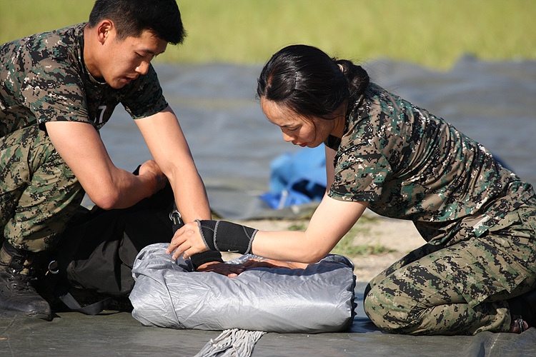 “나라 지키는데 남녀가 따로 있나요?” 무사히 착지한 여군 특전대원이 낙하산을 접고 있다.