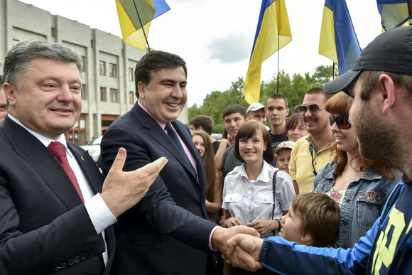 우크라이나 오데사 주지사로 임명된 미하일 사카슈빌리(왼쪽 두 번째) 전 조지아 대통령이 30일 오데사 주청사 앞에서 주민들과 이야기하며 악수를 나누고 있다. 왼쪽은 페트로 포로셴코 우크라이나 대통령.  우크라이나 대통령실 제공 